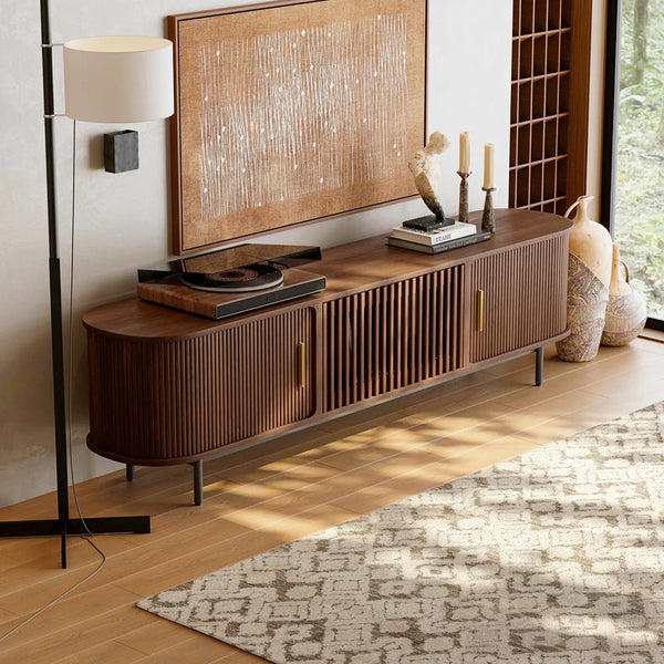 Wooden mid century tv stand with decorative items in a living room setting