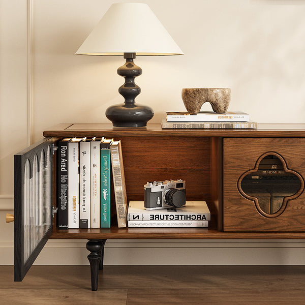 Wooden tv stand with shelf for books, a camera, and a lamp on a neutral background